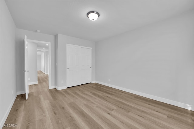 unfurnished bedroom featuring a closet and light hardwood / wood-style flooring