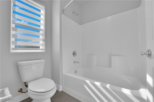 bathroom with tile patterned flooring, toilet, a wealth of natural light, and bathtub / shower combination