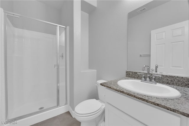 bathroom featuring a shower with door, vanity, and toilet