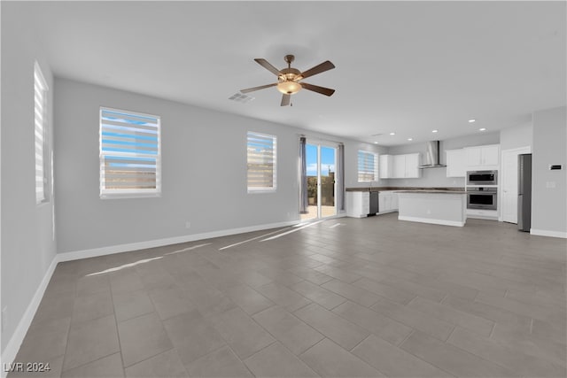 unfurnished living room featuring ceiling fan and light tile patterned floors