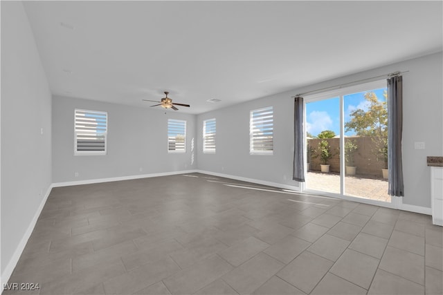 empty room with ceiling fan and light tile patterned floors