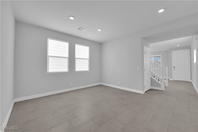 empty room with a wealth of natural light and light tile patterned flooring