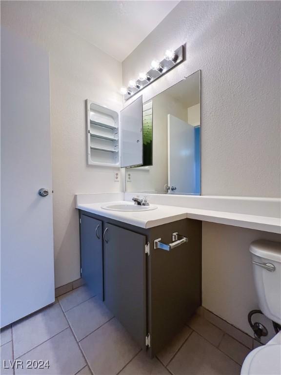 bathroom with vanity, toilet, and tile patterned flooring