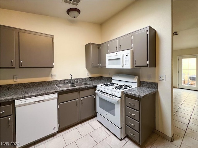 kitchen featuring gray cabinets, sink, light tile patterned floors, and white appliances