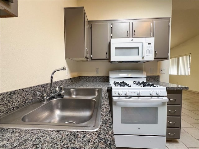 kitchen featuring sink, white appliances, and light tile patterned floors