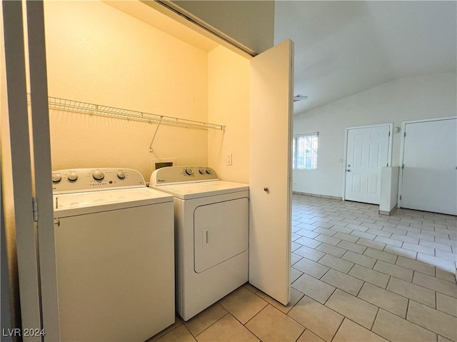 laundry area with separate washer and dryer and light tile patterned floors