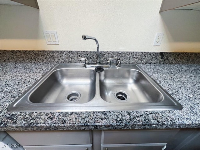 interior details featuring sink and dark stone counters