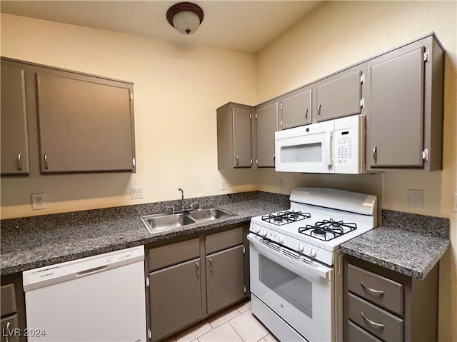 kitchen featuring white appliances, gray cabinets, sink, and light tile patterned floors