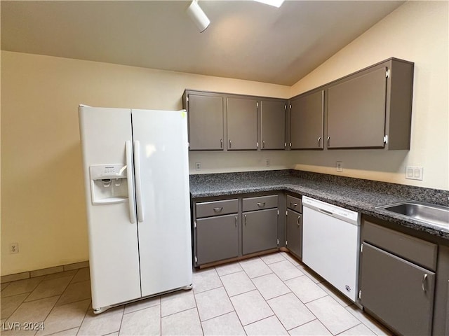 kitchen with sink, white appliances, gray cabinetry, light tile patterned flooring, and vaulted ceiling