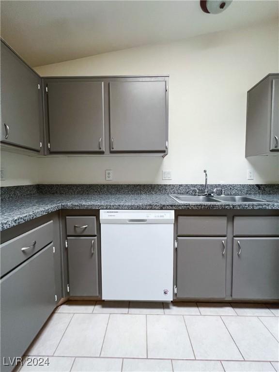 kitchen featuring lofted ceiling, white dishwasher, gray cabinets, and sink