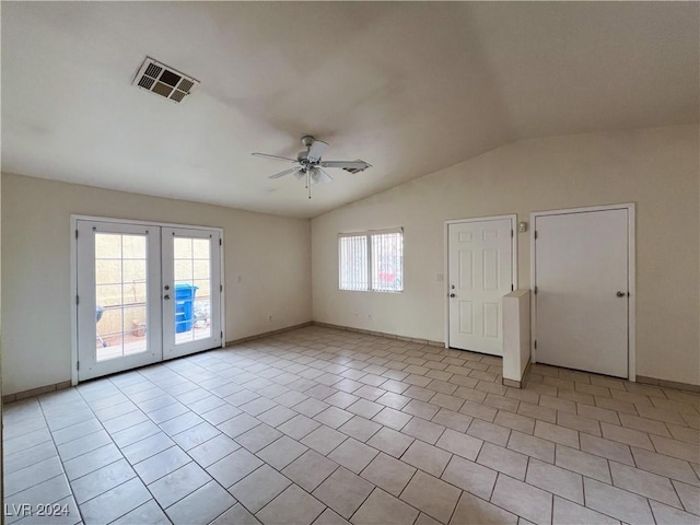 tiled spare room featuring vaulted ceiling, ceiling fan, and french doors