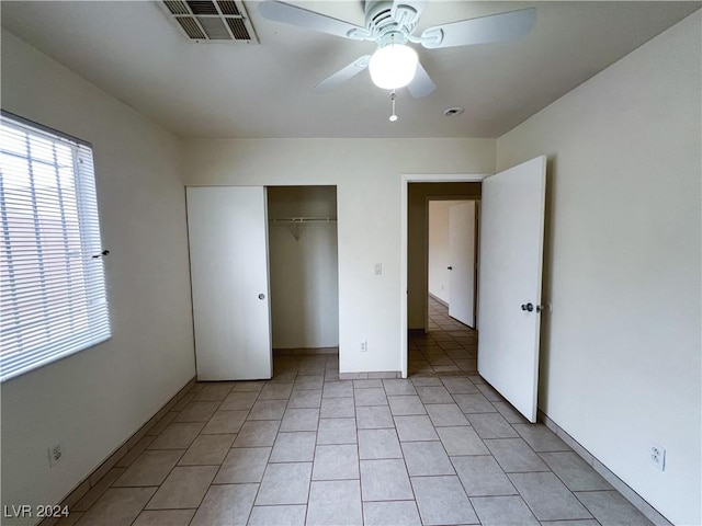 unfurnished bedroom featuring light tile patterned flooring, ceiling fan, and a closet