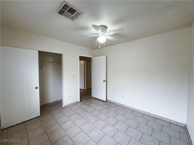 unfurnished bedroom with light tile patterned floors, a closet, and ceiling fan