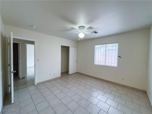 unfurnished bedroom featuring a closet, ceiling fan, and light tile patterned flooring