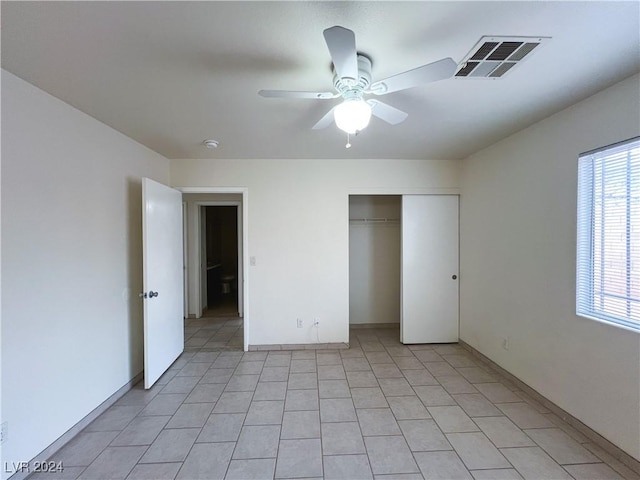 unfurnished bedroom with light tile patterned floors, a closet, and ceiling fan