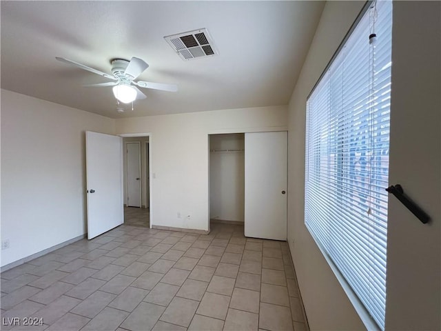 unfurnished bedroom with ceiling fan and a closet