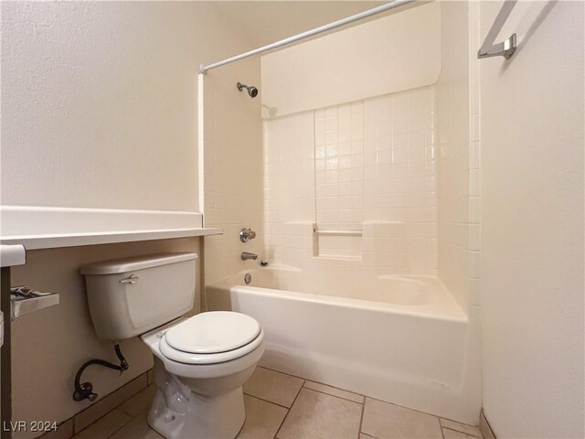 bathroom featuring bathing tub / shower combination, tile patterned floors, and toilet