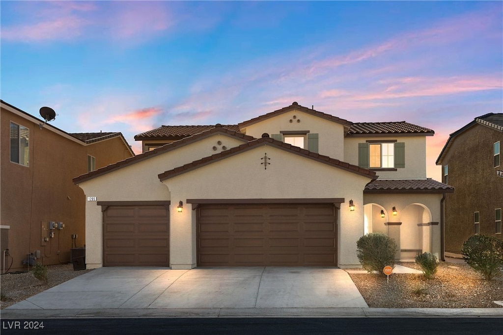 mediterranean / spanish home featuring a garage