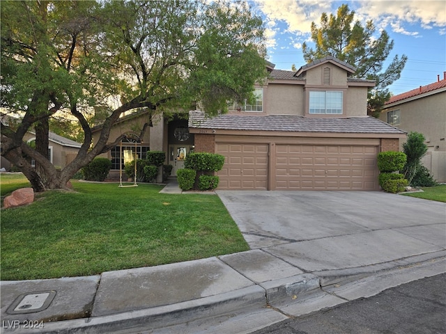 view of front of house featuring a garage and a front lawn