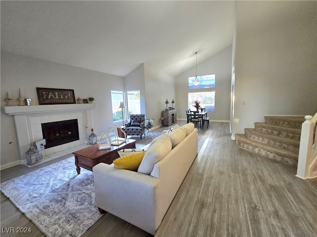 living room featuring hardwood / wood-style flooring, plenty of natural light, a fireplace, and high vaulted ceiling