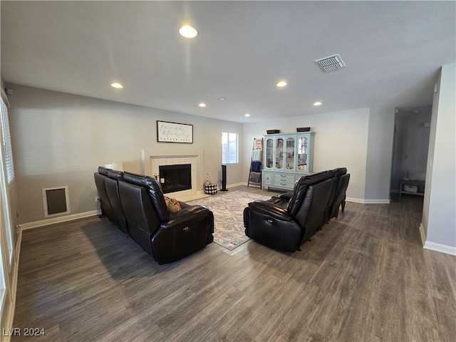 living room featuring wood-type flooring and a tiled fireplace