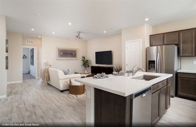 kitchen with dark brown cabinetry, stainless steel appliances, ceiling fan, a center island with sink, and light hardwood / wood-style floors