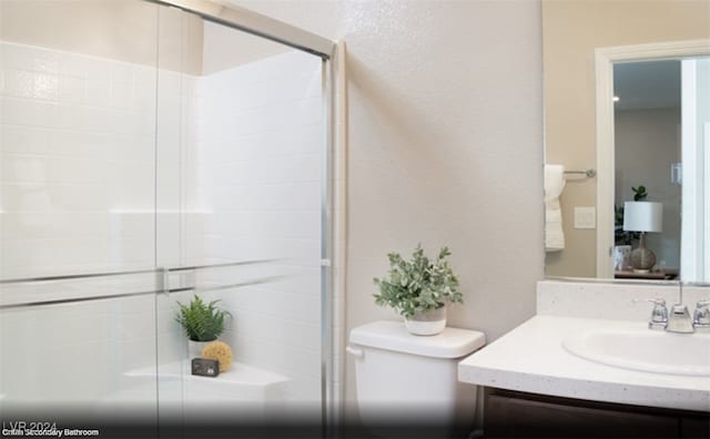 bathroom featuring toilet, an enclosed shower, and vanity