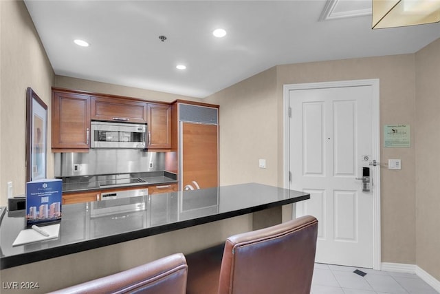 kitchen featuring light tile patterned floors, backsplash, and stainless steel appliances