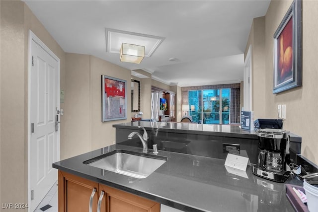 kitchen featuring kitchen peninsula, sink, and light tile patterned floors