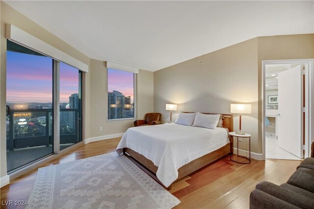 bedroom with access to exterior and light hardwood / wood-style flooring