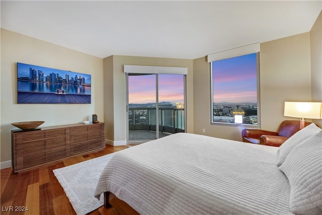 bedroom with hardwood / wood-style floors and access to outside