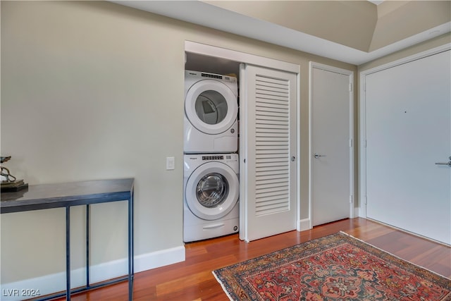 clothes washing area featuring stacked washing maching and dryer and hardwood / wood-style floors