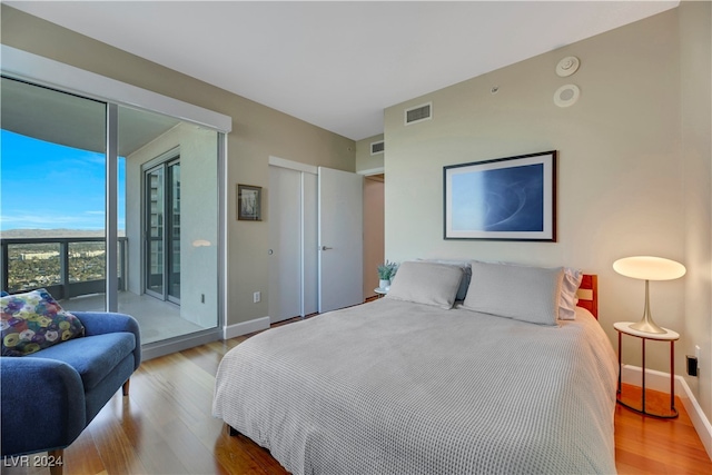 bedroom featuring light wood-type flooring and access to outside