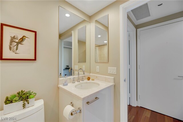 bathroom featuring hardwood / wood-style floors, vanity, and toilet