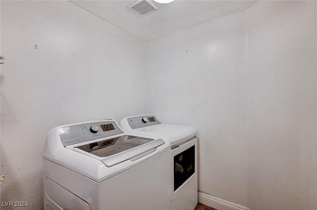 laundry room with laundry area, visible vents, washer and clothes dryer, and baseboards