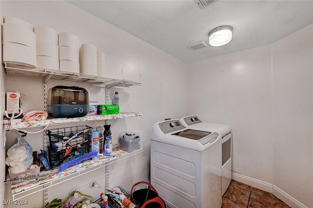 clothes washing area featuring laundry area, washing machine and dryer, visible vents, and baseboards