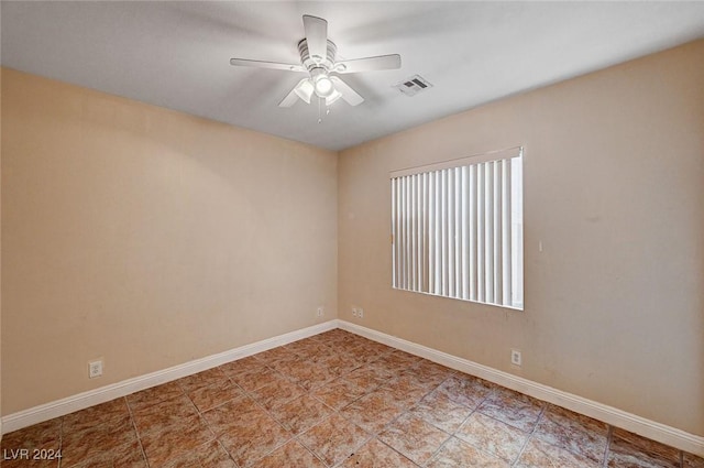 empty room featuring visible vents, ceiling fan, and baseboards