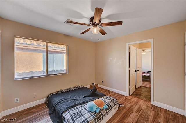 bedroom with ceiling fan, baseboards, and wood finished floors