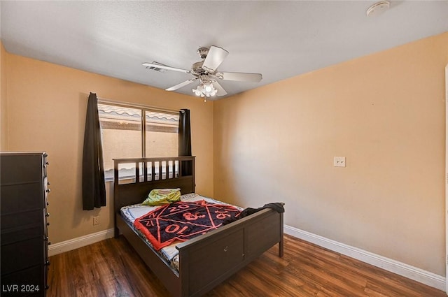 bedroom with a ceiling fan, baseboards, and wood finished floors