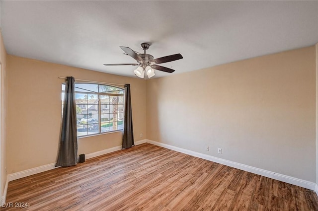 empty room featuring light wood finished floors, ceiling fan, and baseboards