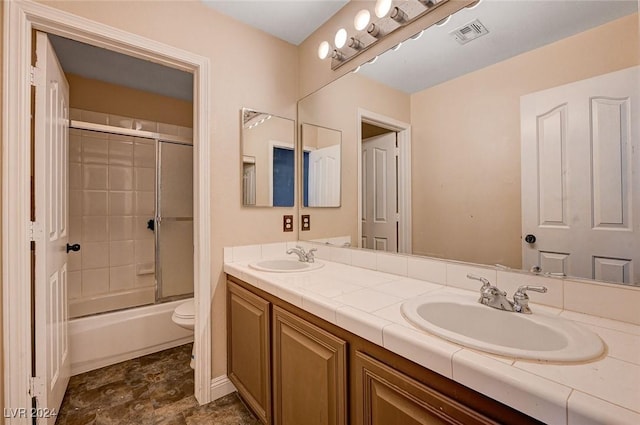 bathroom featuring visible vents, a sink, toilet, and double vanity