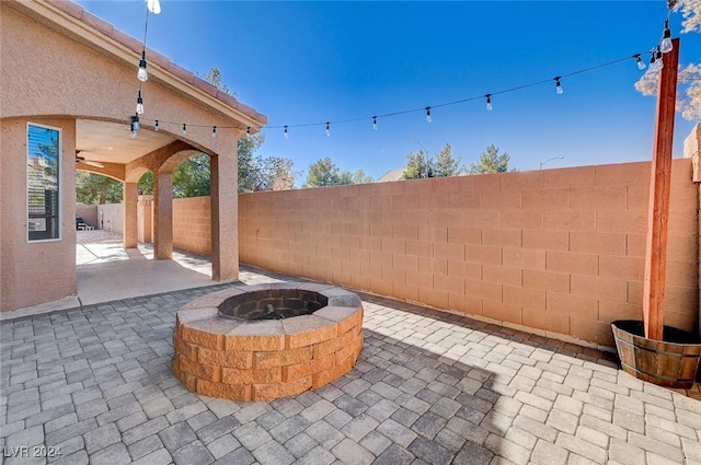 view of patio / terrace with a fenced backyard, ceiling fan, and a fire pit