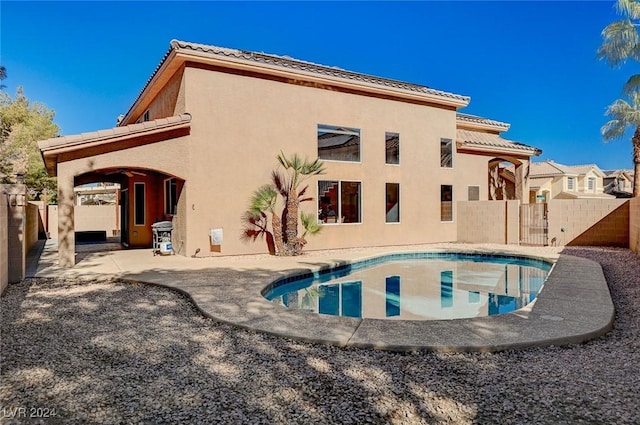 exterior space featuring a fenced in pool, a tile roof, stucco siding, a patio area, and fence