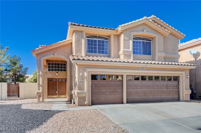 mediterranean / spanish-style house featuring a tile roof, stucco siding, fence, a garage, and driveway