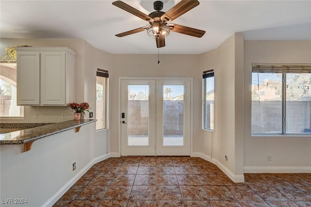 doorway featuring baseboards, a ceiling fan, and french doors