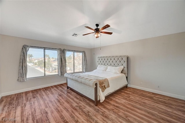 unfurnished bedroom with baseboards, visible vents, ceiling fan, and wood finished floors