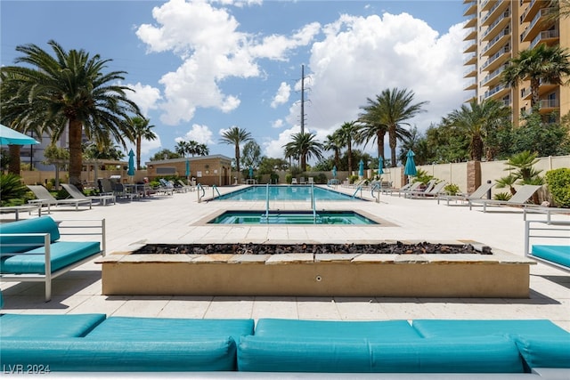 view of swimming pool featuring a community hot tub and a patio