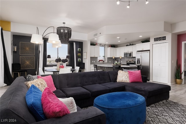 living room with a chandelier and light wood-type flooring