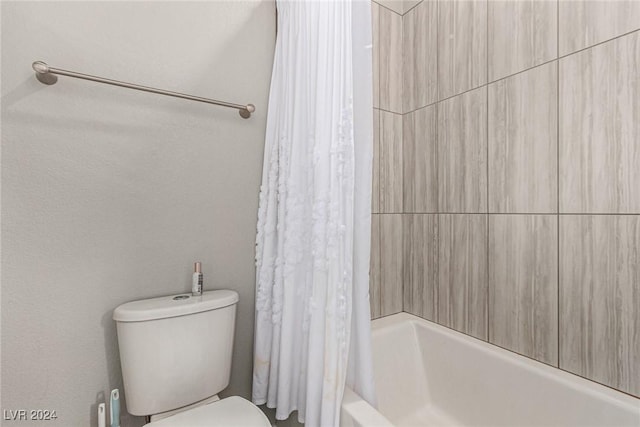 bathroom featuring shower / bath combo and toilet