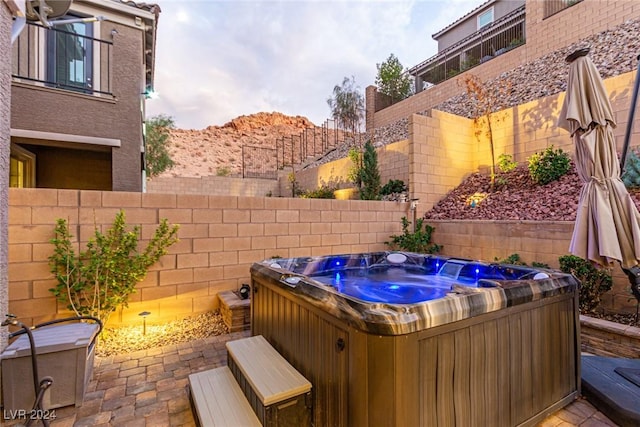 view of patio / terrace with a hot tub and a mountain view